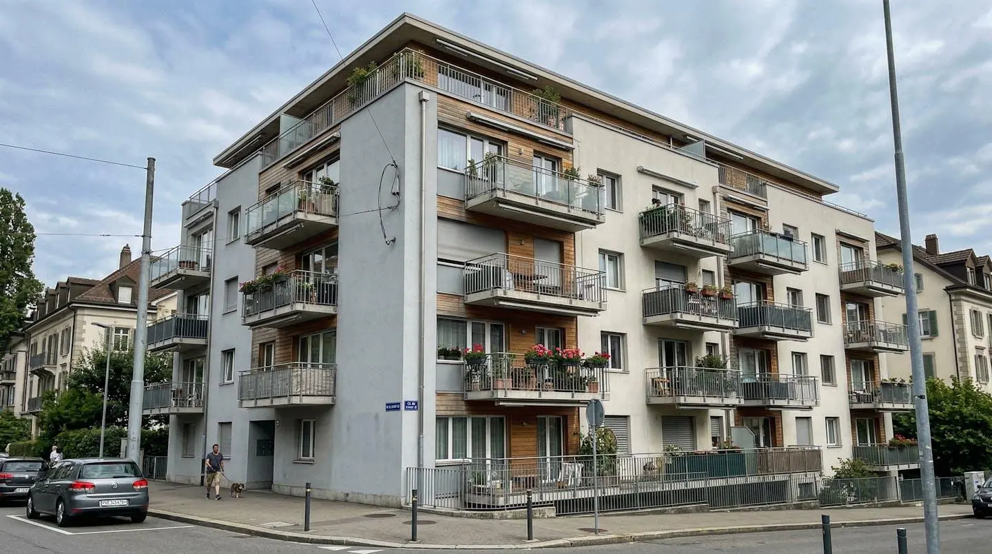 Façade d'un immeuble résidentiel contemporain avec balcons, typique de l'architecture lausannoise, vue depuis la rue